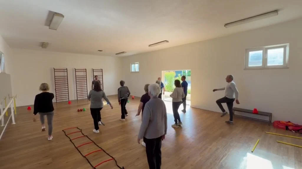 Grupo do Viver Ativo em sessão interior com vários participantes em atividade